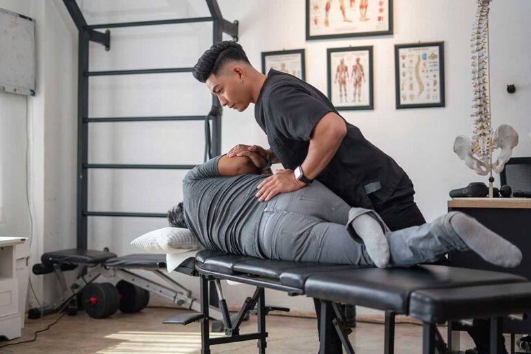 A chiropractor performing a gentle adjustment on a person lying on a treatment table.